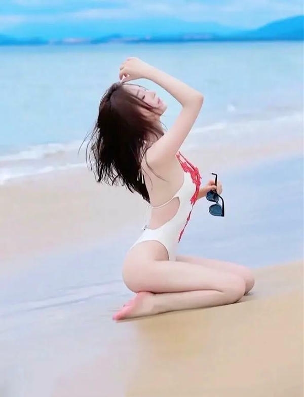 Cô gái bikini đứng cạnh làn sóng nhẹ