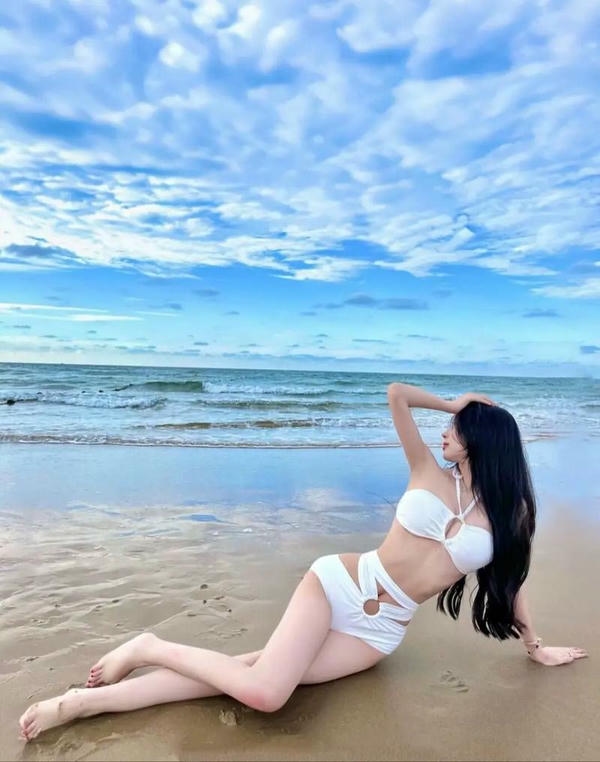 Cô gái bikini đứng trên bãi biển nhiệt đới